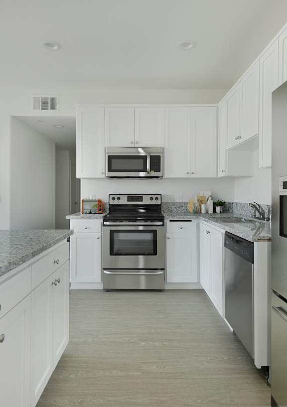 A modern kitchen with stainless steel appliances and white cabinets.at 422 South Lake, Los Angeles