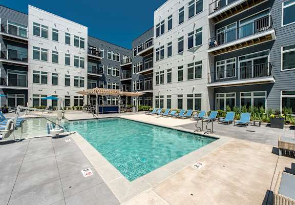 A swimming pool surrounded by apartment buildings.