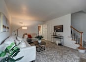Thumbnail 2 of 26 - A living room with a white couch and a coffee table.