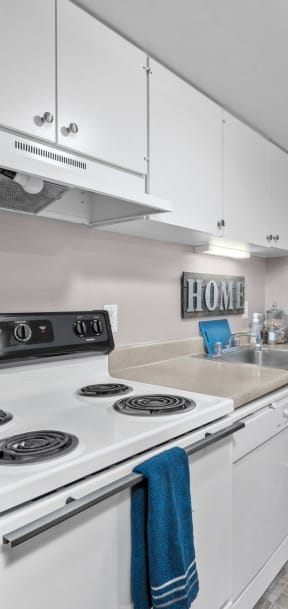 a kitchen with white cabinets and a white stove top oven