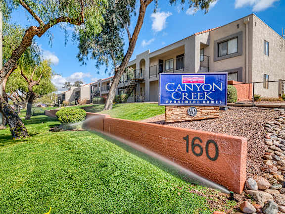 A sign for Canyon Creek is in front of a building.