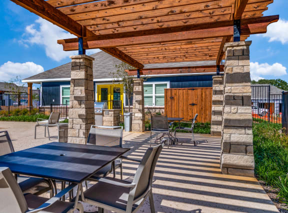 a patio with tables and chairs and a pergola
