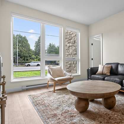 A living room with a black couch and a wooden coffee table.