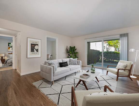 a living room with white furniture and a sliding glass door at Rush River Apartments, California