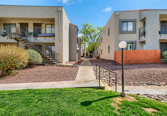 A sunny day at a residential area with apartment buildings and a clear blue sky.