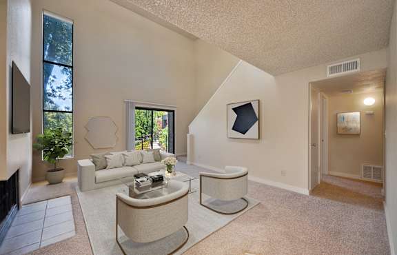 a living room with a couch and a table and a fireplace at Fountains of Fair Oaks, Fair Oaks