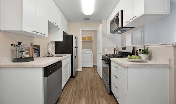 a spacious kitchen with white cabinets and stainless steel appliances  at Cobblestone Creek Apartments, Roseville, CA
