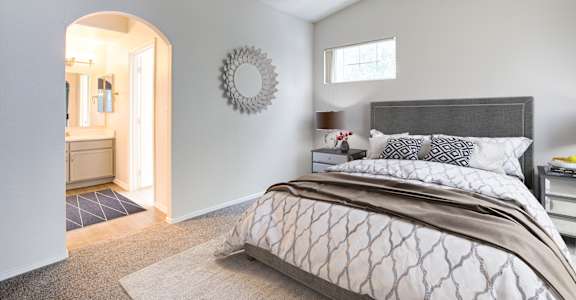 A bedroom with a large bed and a mirror on the wall.