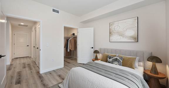 A bedroom with a large bed and a painting on the wall.