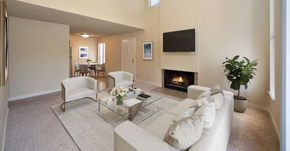 a living room with a couch and a table and a fireplace at Fountains of Fair Oaks, Fair Oaks