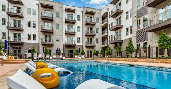 A modern pool with a slide in front of apartment buildings.