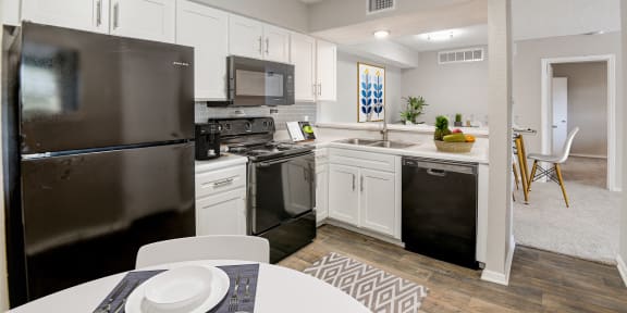 a kitchen with white cabinetry and black appliances