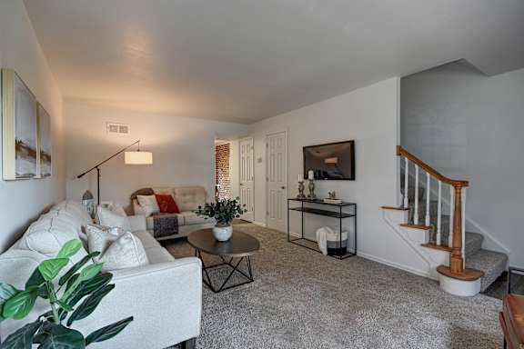 A living room with a white couch and a coffee table.