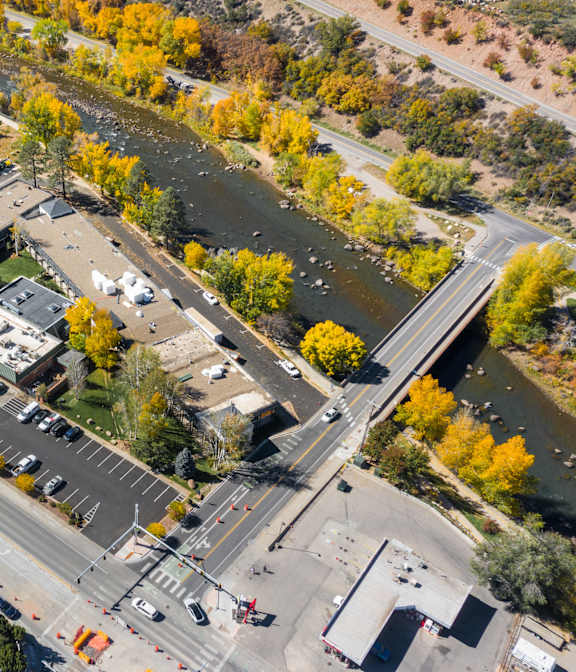 An aerial view of a parking lot and buildings with a river in the background.