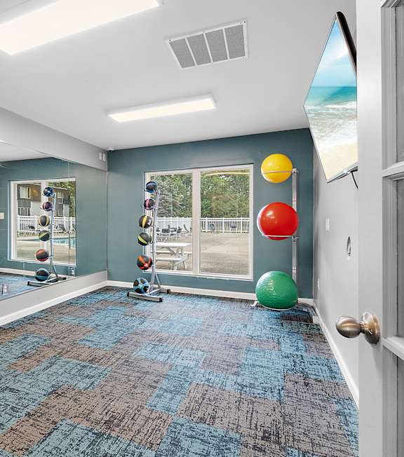 A room with a blue carpet and a mirror on the wall.