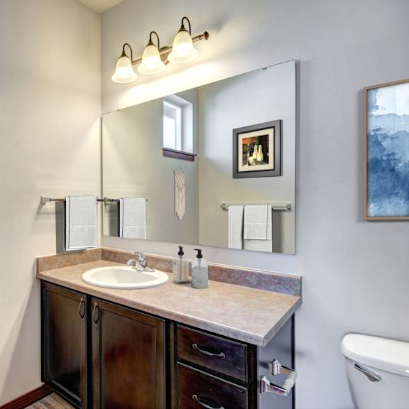 A bathroom with a sink, mirror, and toilet.