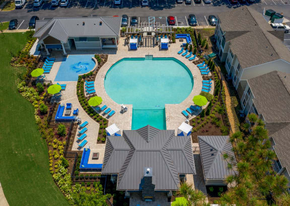 an aerial view of a resort style swimming pool with lounge chairs around it