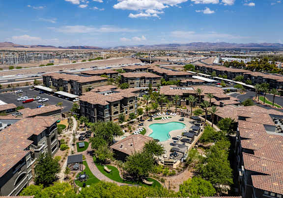 A large resort with a pool and a mountain in the background.