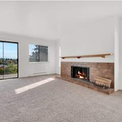 an empty living room with a fireplace and a large window