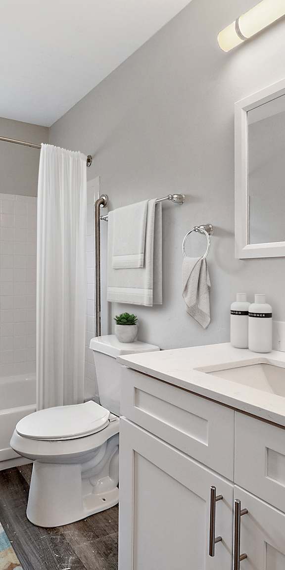 A white bathroom with a toilet, sink, and tub.