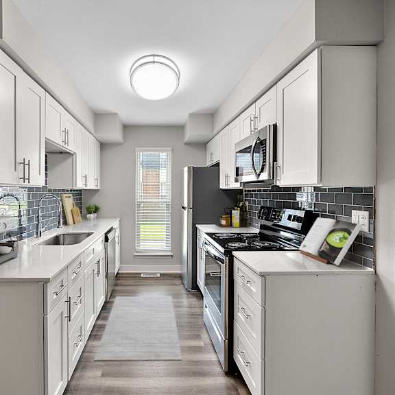 A modern kitchen with white cabinets and appliances.