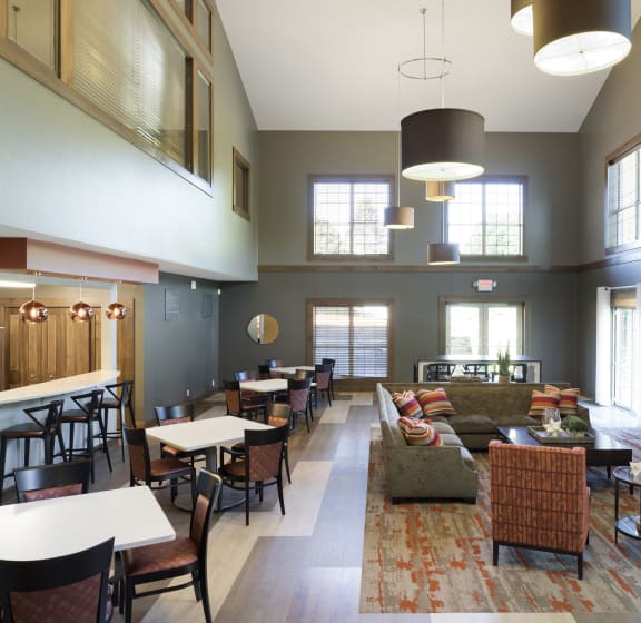 a large living room with a fireplace and tables and chairs  at Regency Woods, Minnetonka, Minnesota