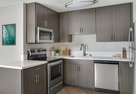 A modern kitchen with a stainless steel dishwasher and a white countertop.