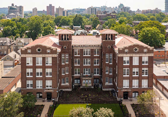 a large brick building with a city in the background