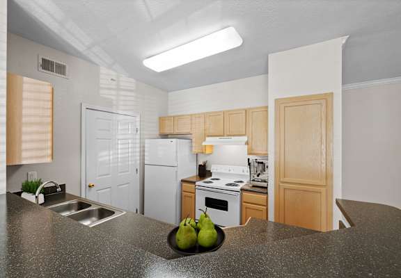 A kitchen with a white fridge and stove top oven.at Crowne Chase Apartment Homes, Kansas, 66210