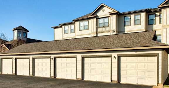 A large house with a tower and a long row of garages.