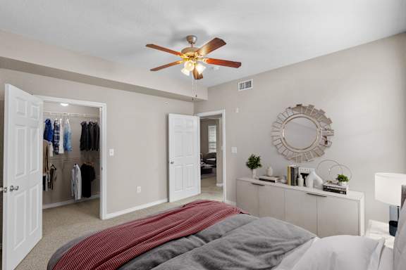 a bedroom with a large bed and a ceiling fan