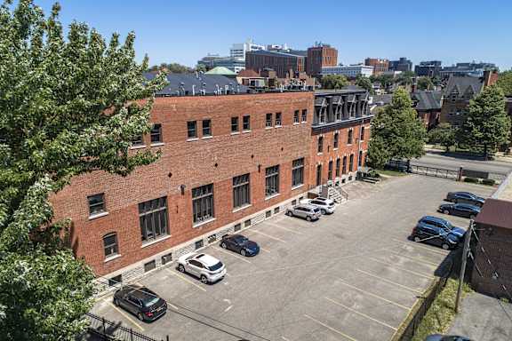 an aerial view of a brick building in a parking lot at The Knights @ 506 Delaware Apartments, Buffalo, 14202