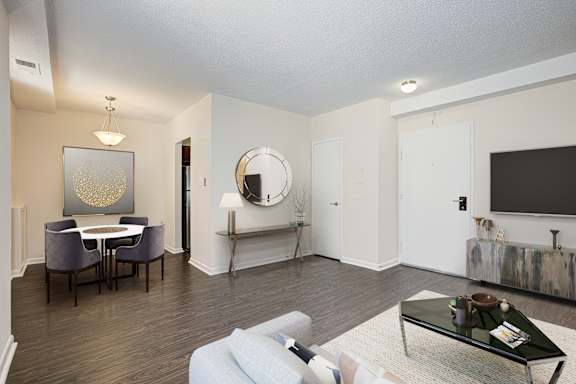 A living room with a white couch, a coffee table, and a painting on the wall. at Columbia Uptown Apartments, Washington, 20009