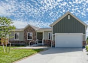 Thumbnail 4 of 8 - a home with a white garage door and a stone house