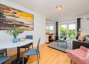 Thumbnail 2 of 5 - a living room with a table and chairs and a couch