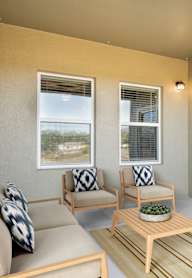 A patio with a couch, chairs, and a table.