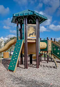 A playground with a slide and a wooden structure.