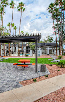 A patio with a table and chairs is surrounded by trees.