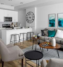a kitchen and living room with a large island with stools