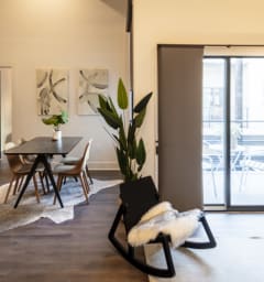 a living room with a dining room table and sliding glass doors