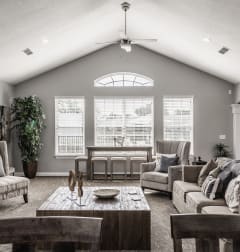 a living room with a vaulted ceiling and a large window