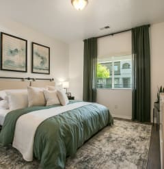 a bedroom with a green and white bed and a window