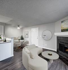 A modern living room with a fireplace and a dining area.