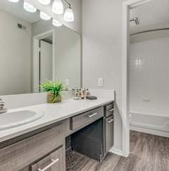 A bathroom with a white sink and a mirror above it.