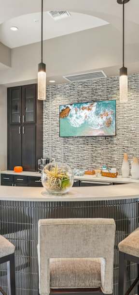 A kitchen with a white island and black cabinets.