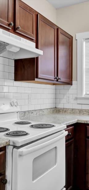 an updated kitchen with white appliances and granite counter tops