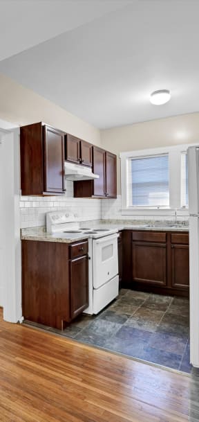 a renovated kitchen with white appliances and wooden floors
