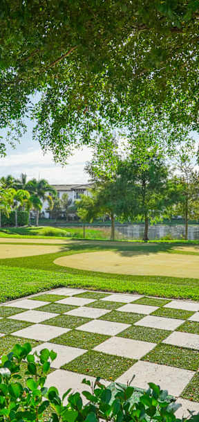 A large white building with a green lawn in front.