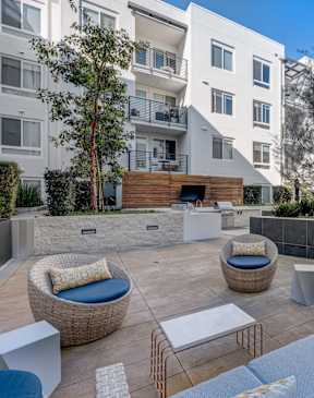 an outdoor patio area with couches and chairs and a fire pit