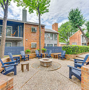our apartments have a spacious courtyard with a grill and trees at The Manhattan Apartments, Dallas, TX, 75252